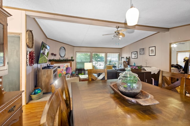 dining room featuring ceiling fan, vaulted ceiling with beams, crown molding, light hardwood / wood-style floors, and a textured ceiling