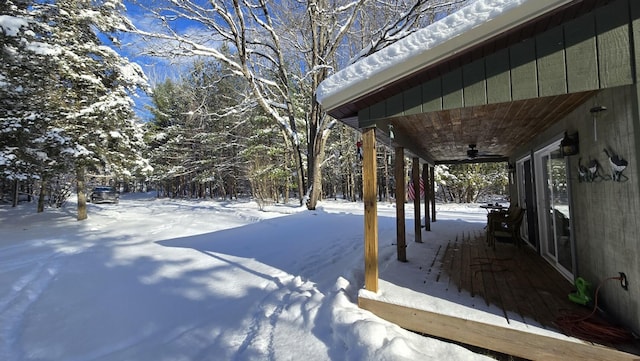 snowy yard featuring ceiling fan