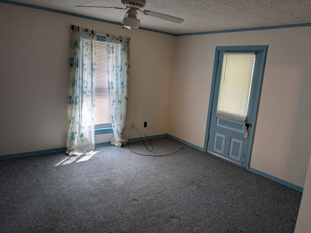 carpeted empty room featuring ceiling fan, ornamental molding, a textured ceiling, and a wealth of natural light