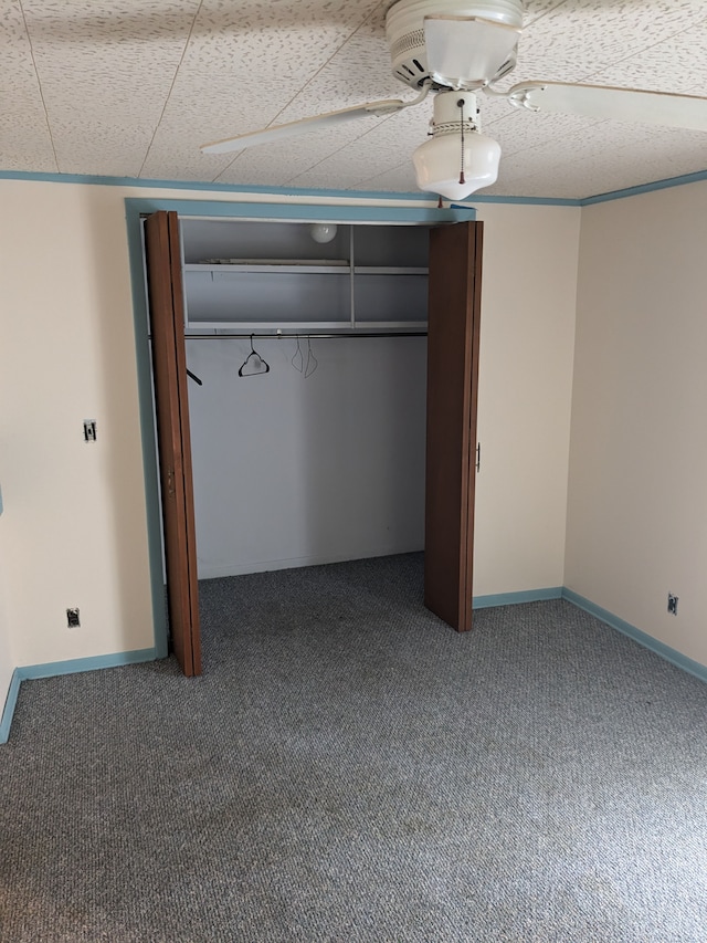 unfurnished bedroom featuring ceiling fan, a closet, and carpet floors