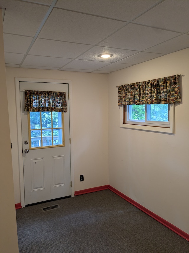 doorway to outside featuring plenty of natural light, carpet, and a drop ceiling