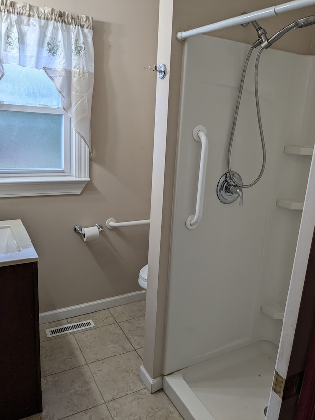 bathroom with a shower, vanity, toilet, and tile patterned flooring