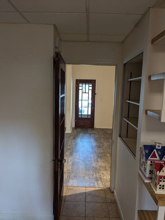 hallway featuring a drop ceiling and wood-type flooring