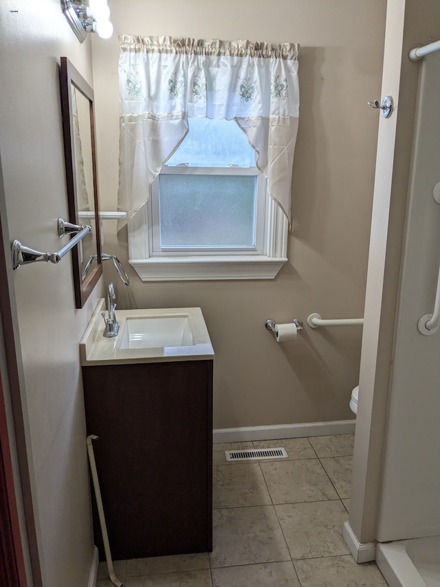 bathroom with tile patterned flooring, vanity, and toilet