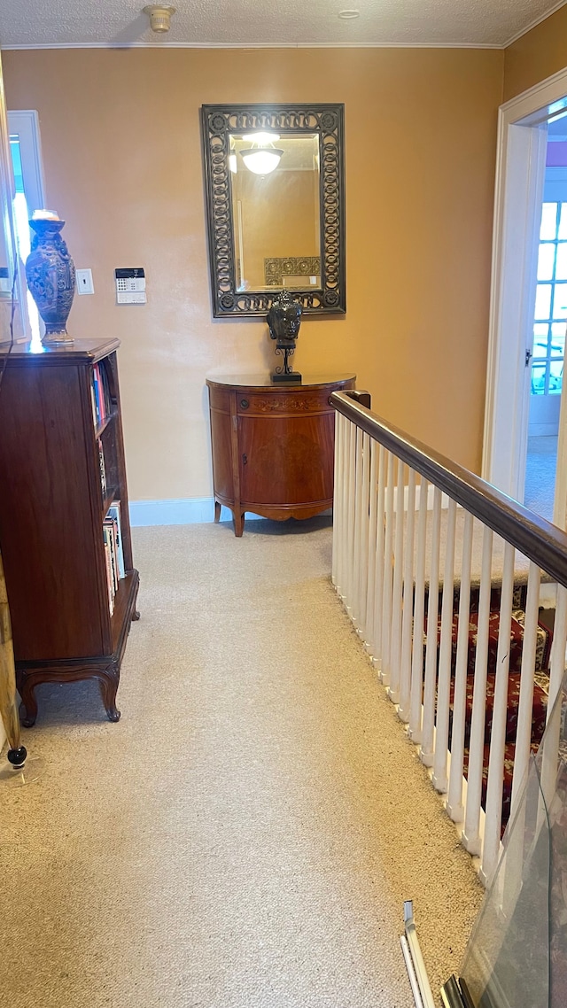 corridor featuring light colored carpet and a textured ceiling