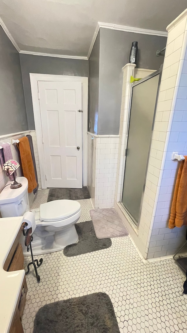 bathroom featuring crown molding, vanity, toilet, and an enclosed shower