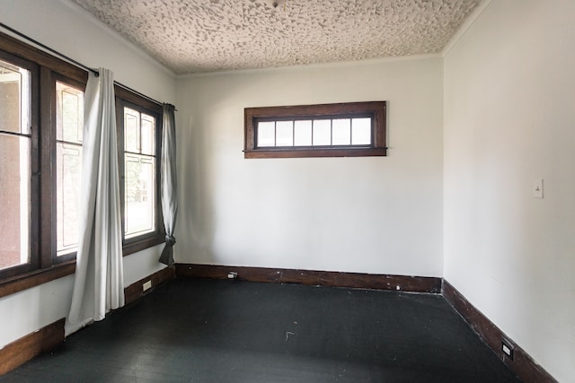 empty room with a healthy amount of sunlight and a textured ceiling