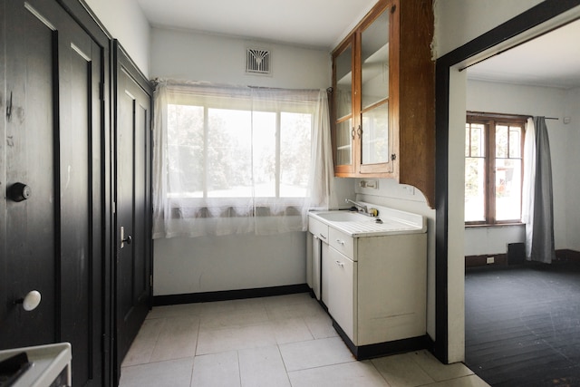 laundry area with light tile patterned floors and sink