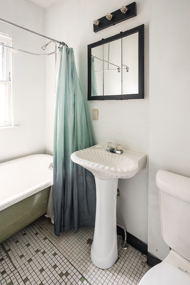 bathroom featuring tile patterned floors, shower / bathtub combination with curtain, and toilet