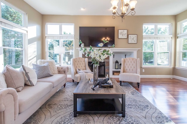 living room with a chandelier, hardwood / wood-style flooring, and a tiled fireplace