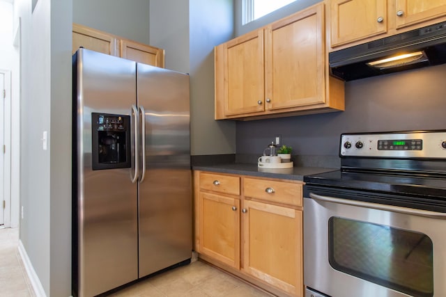 kitchen with light brown cabinets, light tile patterned flooring, and stainless steel appliances