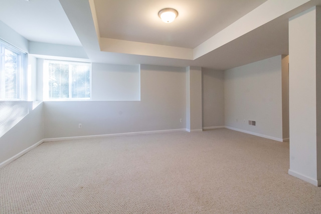 interior space featuring light carpet and a tray ceiling