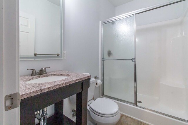 bathroom with toilet, walk in shower, and sink