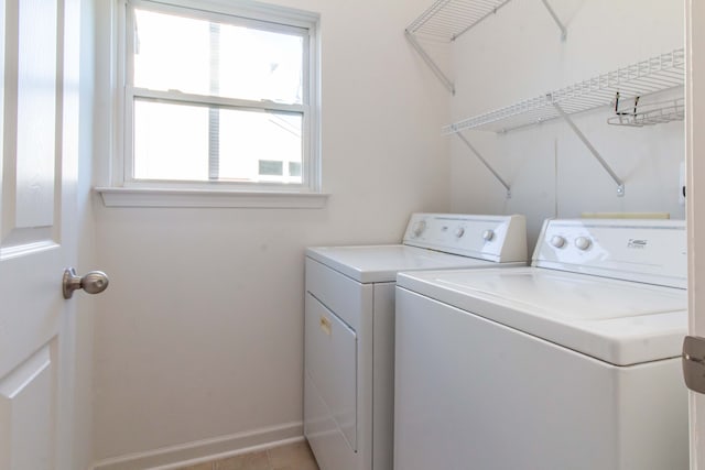 laundry room featuring washing machine and clothes dryer and light tile patterned flooring