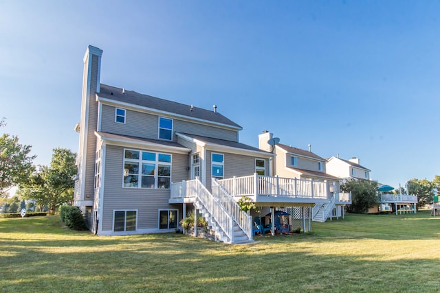 rear view of house with a yard and a wooden deck