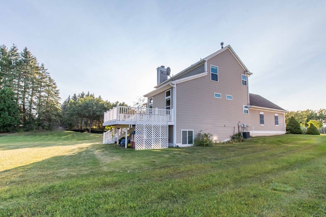 view of side of property featuring central air condition unit, a lawn, and a wooden deck