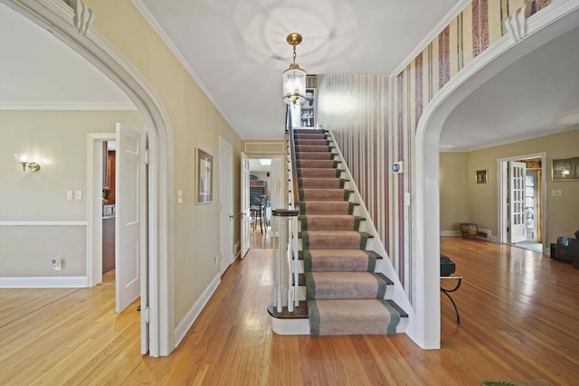 staircase with hardwood / wood-style flooring and ornamental molding