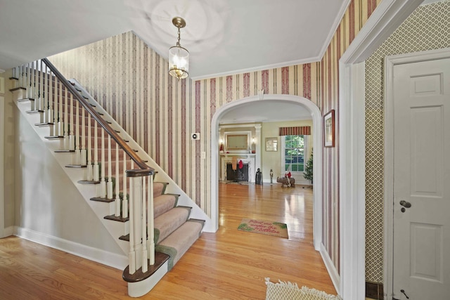 foyer entrance featuring hardwood / wood-style flooring and crown molding