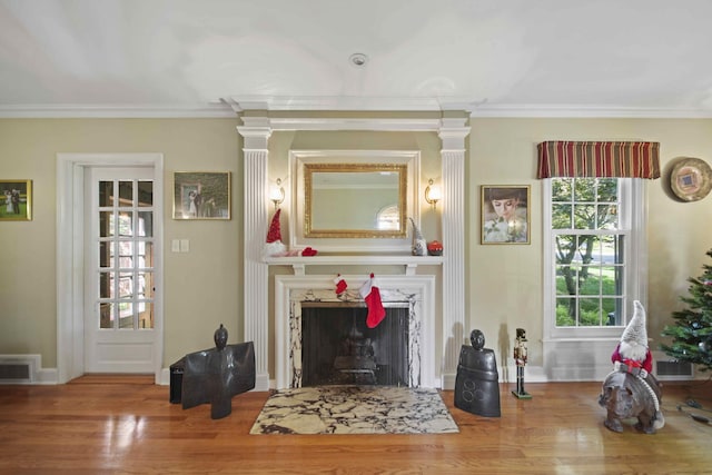 living room with crown molding, a high end fireplace, and wood-type flooring