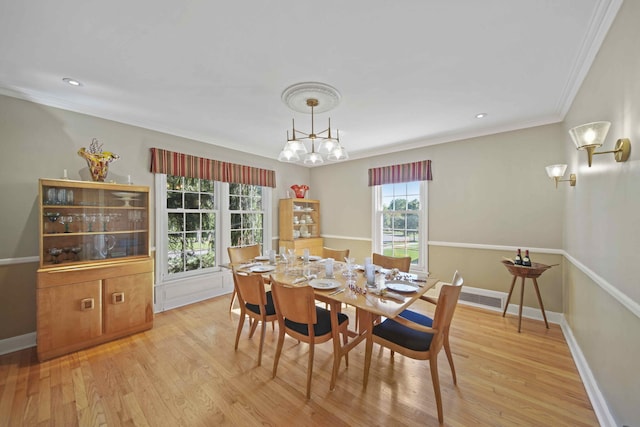 dining space featuring light wood-type flooring and crown molding