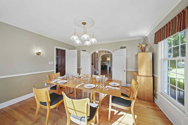 dining area featuring a chandelier, light hardwood / wood-style flooring, and crown molding