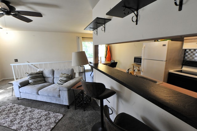 living room with dark colored carpet, ceiling fan, and sink