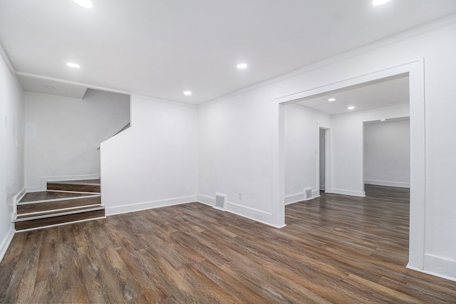 basement with dark wood-type flooring and ornamental molding