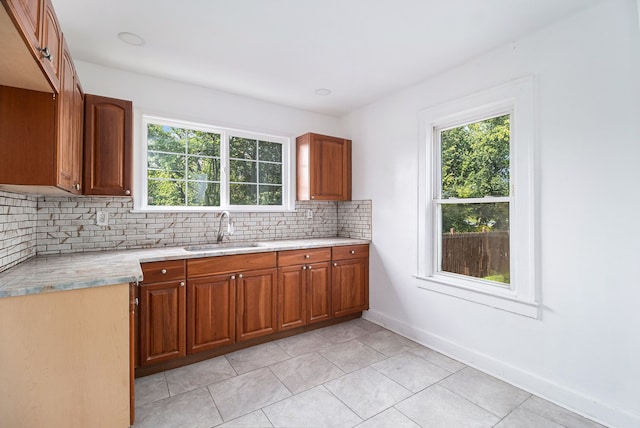 kitchen featuring decorative backsplash, light tile patterned flooring, and sink