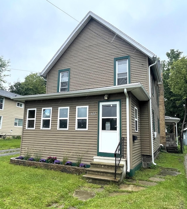 back of house featuring a lawn