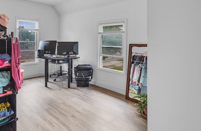 office with light hardwood / wood-style flooring and lofted ceiling