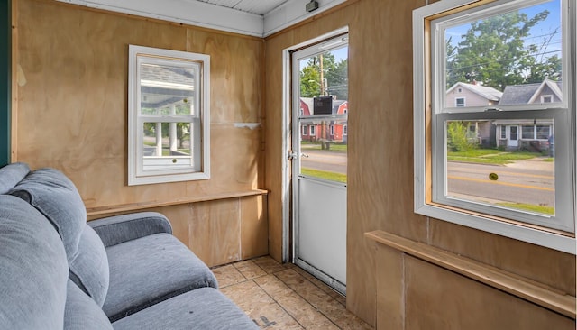 doorway to outside with wood walls