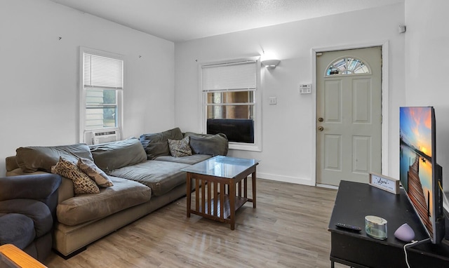 living room with a textured ceiling, light hardwood / wood-style floors, and cooling unit