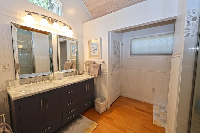 93810 Lake Ct, Dowagiac, MI 49047 - bathroom with a wainscoted wall, double vanity, wood finished floors, a stall shower, and lofted ceiling