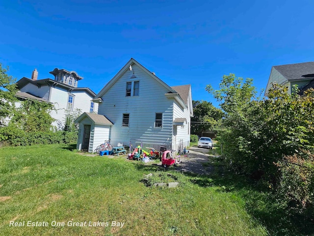 rear view of property featuring a lawn