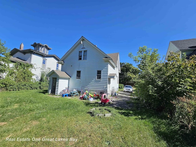 1209 S Fayette St, Saginaw, MI 48602 - back of house with a lawn and a storage unit