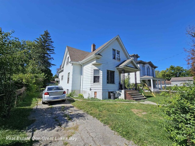 1209 S Fayette St, Saginaw, MI 48602 - view of front of home featuring a chimney, asphalt driveway, and a shingled roof