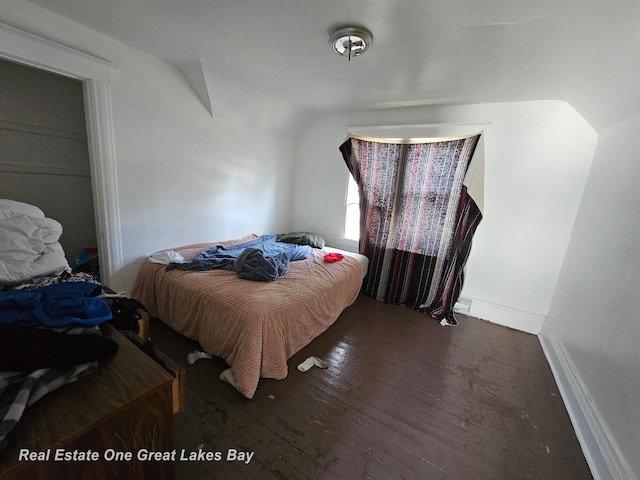 bedroom with dark hardwood / wood-style floors and vaulted ceiling