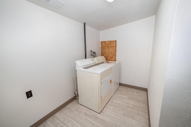 laundry area featuring light hardwood / wood-style flooring and washer and dryer