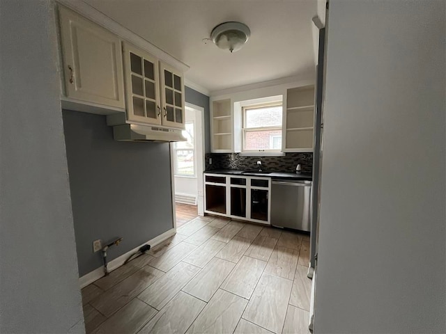 kitchen with decorative backsplash, stainless steel dishwasher, and white cabinets