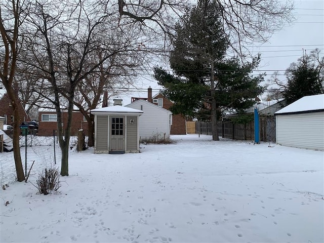 yard covered in snow featuring a shed