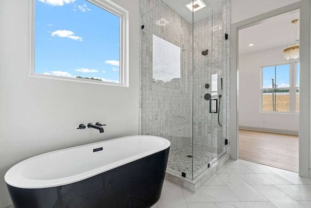 bathroom featuring shower with separate bathtub, hardwood / wood-style flooring, and plenty of natural light