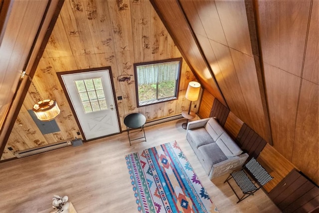 bonus room featuring light hardwood / wood-style floors, vaulted ceiling, wooden walls, and a baseboard heating unit