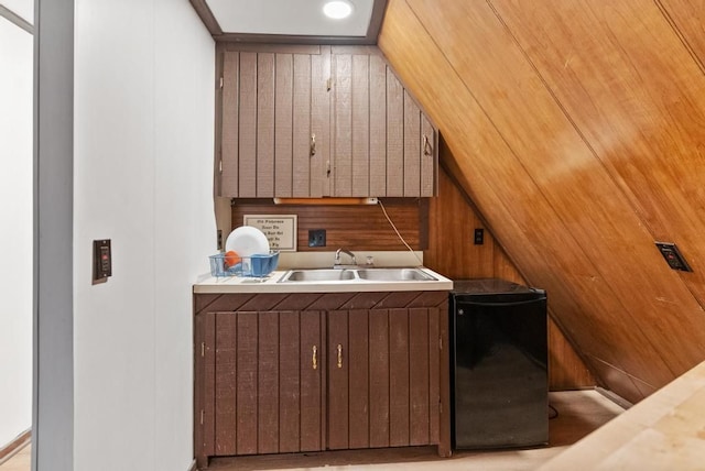 laundry room featuring wood ceiling, wooden walls, and sink