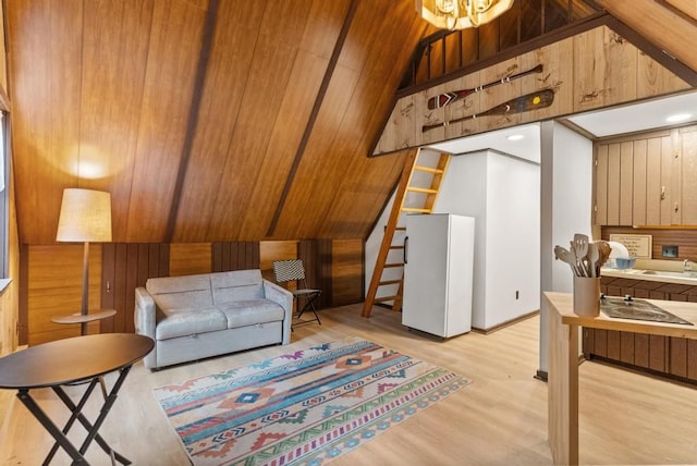 living room featuring light wood-type flooring, wood ceiling, sink, lofted ceiling, and wood walls