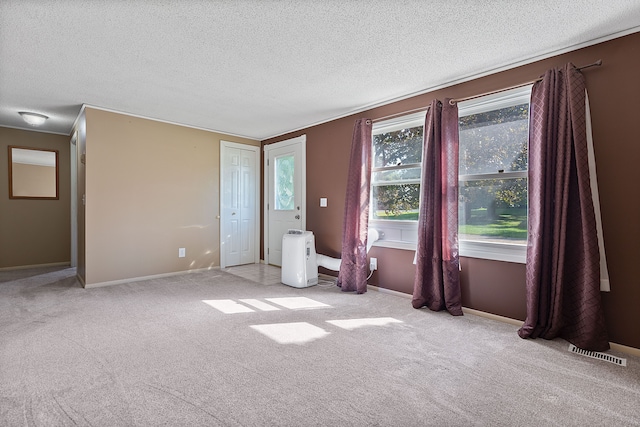 unfurnished bedroom featuring light carpet and a textured ceiling