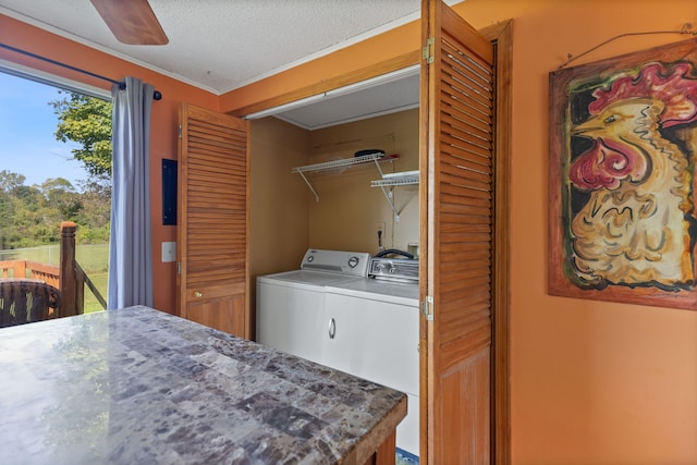 laundry area featuring washing machine and clothes dryer, crown molding, ceiling fan, and a textured ceiling