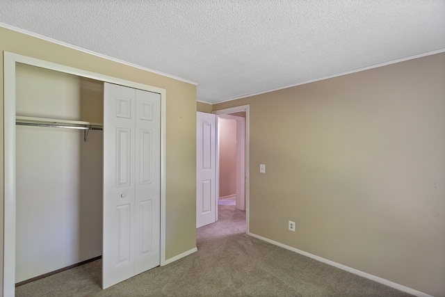 unfurnished bedroom with light carpet, a closet, a textured ceiling, and ornamental molding