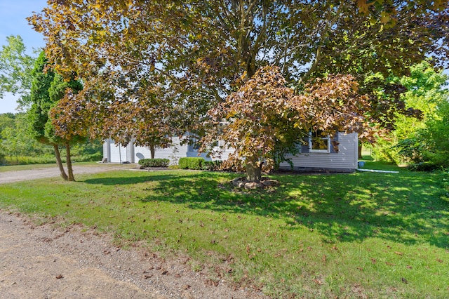 view of property hidden behind natural elements with a front yard