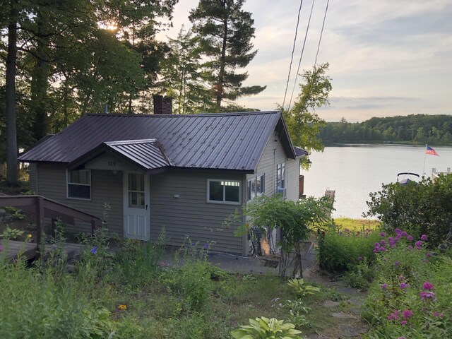 589 E Sidney Rd, Stanton, MI 48888 - view of front of property featuring a chimney, a water view, and metal roof