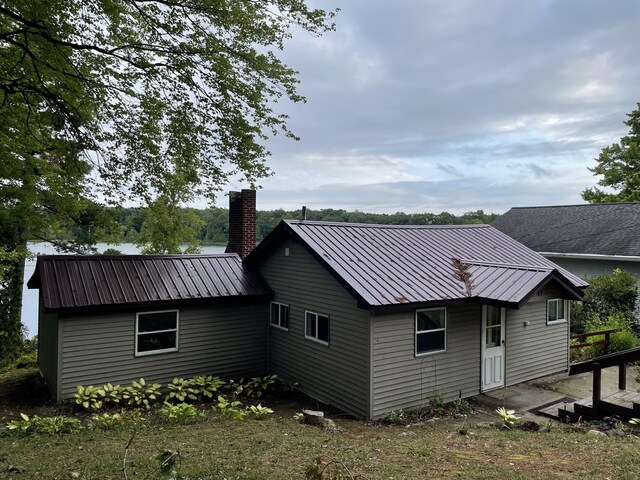 589 E Sidney Rd, Stanton, MI 48888 - rear view of property with a chimney and metal roof